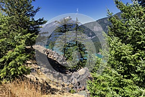 Glacier mountain lake in the north Cascades of Washington State with evergreen trees in foreground