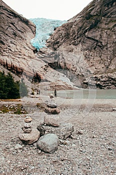 Glacier in norway with piled stones in the foreground