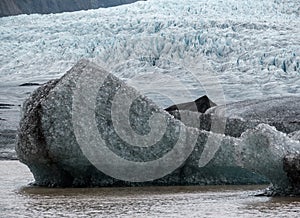 Glacier tongue slides from the Vatnajokull icecap or Vatna Glacier near subglacial Oraefajokull volcano, Iceland. Glacial lagoon