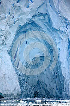 Glacier wall in Antarctica, Majestic blue ice wall with shape of arch.