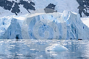 Glacier wall in Antarctica, majestic blue and white ice wall with gate in front.