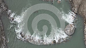 Glacier water flowing over a stone dam in a river