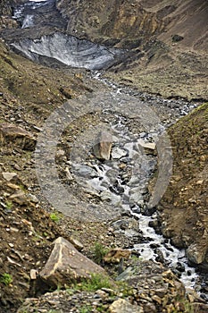 The glaciers covered by the old volcanic rock descend to the edge of Shimshal village, bringing with them the water