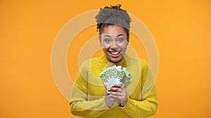 Glad African-American woman holding bunch of euros, high-paying job, salary