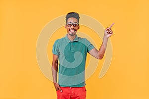 Glad boy in green t-shirt posing in studio with pleasure. Indoor photo of laughing man in trendy ou