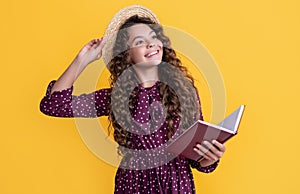 glad child with frizz hair read book on yellow background