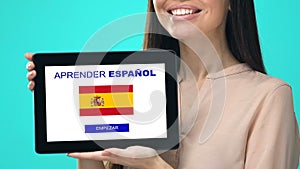 Glad female holding tablet with learn Spanish language app, educational program