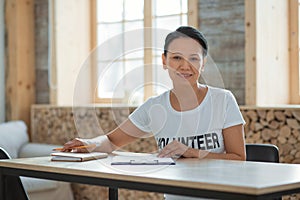 Glad female volunteer compiling list