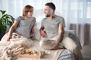 Glad future parents relaxing in bedroom together
