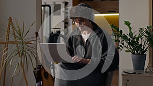 Glad Hispanic guy worker using laptop at home man freelancer typing computer programmer work remote job developer browse