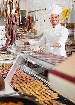 Glad male seller working at meat market