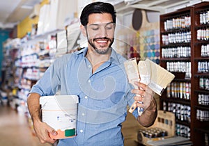 Glad man choosing brushes and varnishes