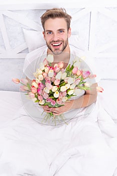 glad man with womens day flowers in sping. photo of man with womens day flowers bouquet