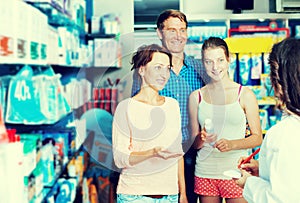 Glad parents with daughter teenager talking to pharmacist