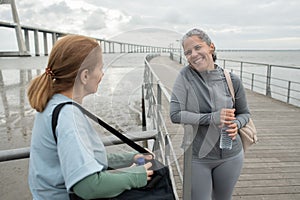 Glad senior friends talking on embankment