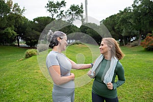 Glad senior friends talking in park