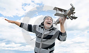 glad senior retired man. mature man at retirement. old man on sky background with toy plane outdoor