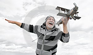 glad senior retired man. mature man at retirement. old man on sky background with toy plane outdoor