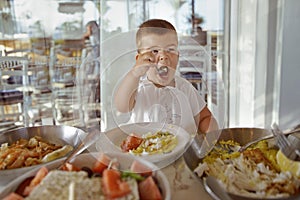 Glad small child eats sea seafood in a restaurant.Healthy food for kids.