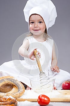 Glad and Smiling Caucasian Girl In Cook Uniform Making a Mix of Flour, Eggs and Vegetables