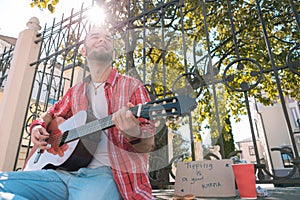 Glad street musician desiring money for play