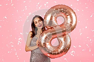 Glad surprised millennial caucasian brunette woman in dress with 8 inflatable balloon