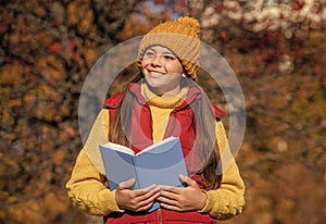 glad teen child read school book in autumn photo