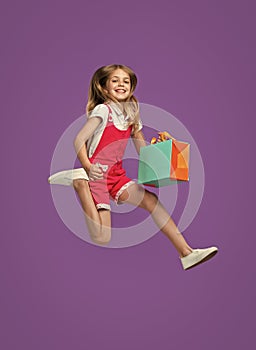 glad teen girl jumping after shopping in studio. teen girl jumping after shopping