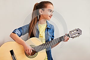 Glad teen guitarist looking away