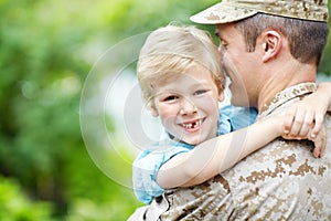 Glad to have his daddy home. Cute little boy hugging his dad after a homecoming - Servicemen.