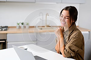 Glad to meet you. Happy young Asian multiracial woman sitting at the desk at home office