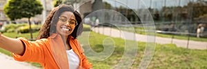 Glad young african american woman in casual, glasses outdoors photo