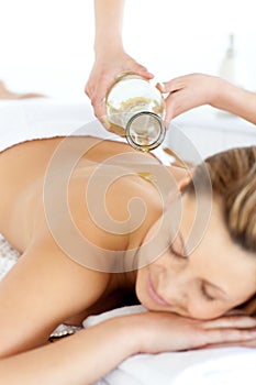 Glad young woman enjoying a back massage with oil