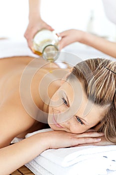 Glad young woman enjoying a back massage with oil photo