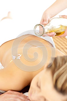 Glad young woman enjoying a back massage with oil photo