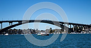 Gladesville Bridge spanning Parramatta River off Sydney Harbour with Rivercat Ferry travelling upstream, many pleasure boats on wa photo