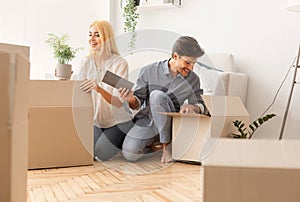 Gladful Couple Unpacking Boxes After Moving Into New Apartment