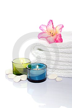 Gladiola, towel, candles and river stones