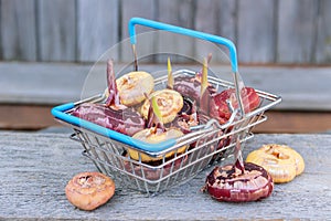 Gladioli bulbs in shop basket with blue handles