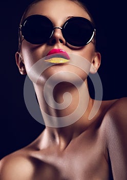 Glamor closeup portrait of beautiful stylish mode in sun glasses with bright colorful lips with perfect clean skin in studio