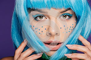 Glamor girl with blue wig, makeup and stars on face, isolated