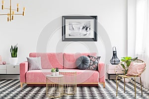 Glamor living room interior with a pink sofa, golden armchair an