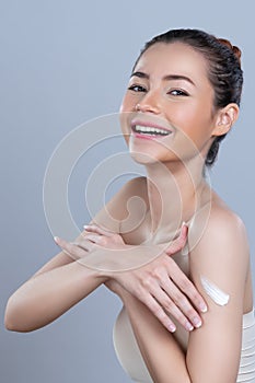 Glamorous beautiful woman applying moisturizer cream on her arm for perfect skin