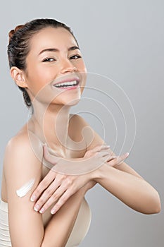 Glamorous beautiful woman applying moisturizer cream on her arm for perfect skin