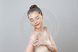 Glamorous beautiful woman applying moisturizer cream on her arm for perfect skin