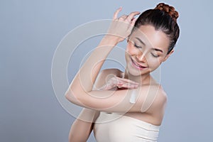 Glamorous beautiful woman applying moisturizer cream on her arm for perfect skin
