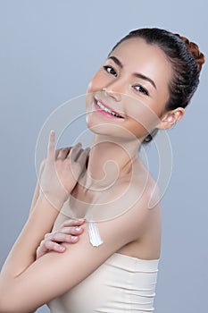 Glamorous beautiful woman applying moisturizer cream on her arm for perfect skin