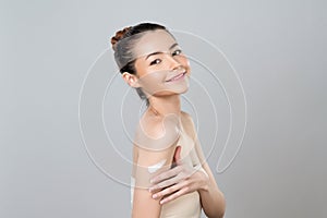 Glamorous beautiful woman applying moisturizer cream on her arm for perfect skin