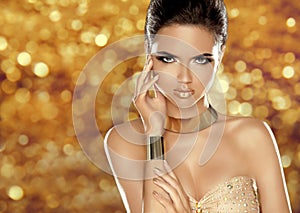 Glamorous beauty fashion girl portrait. Beautiful Young Woman over golden holiday bokeh lights background. Luxury jewelry, makeup