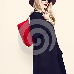 Glamorous blonde in classic black coat and red hat. Autumn fashion style